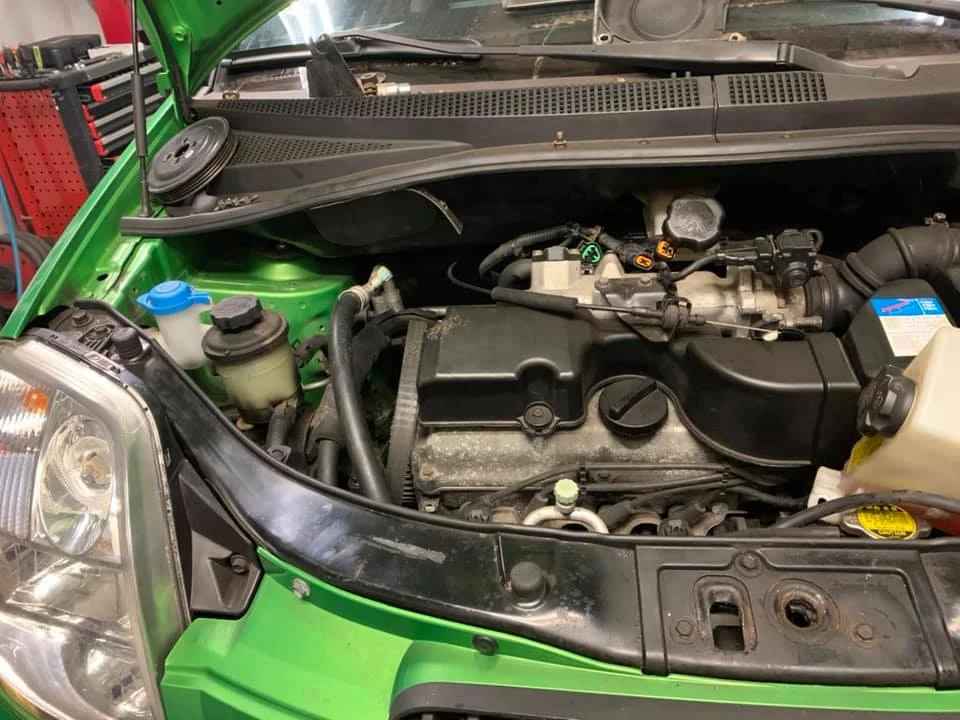 Zielone auto z podniesioną do góry maską