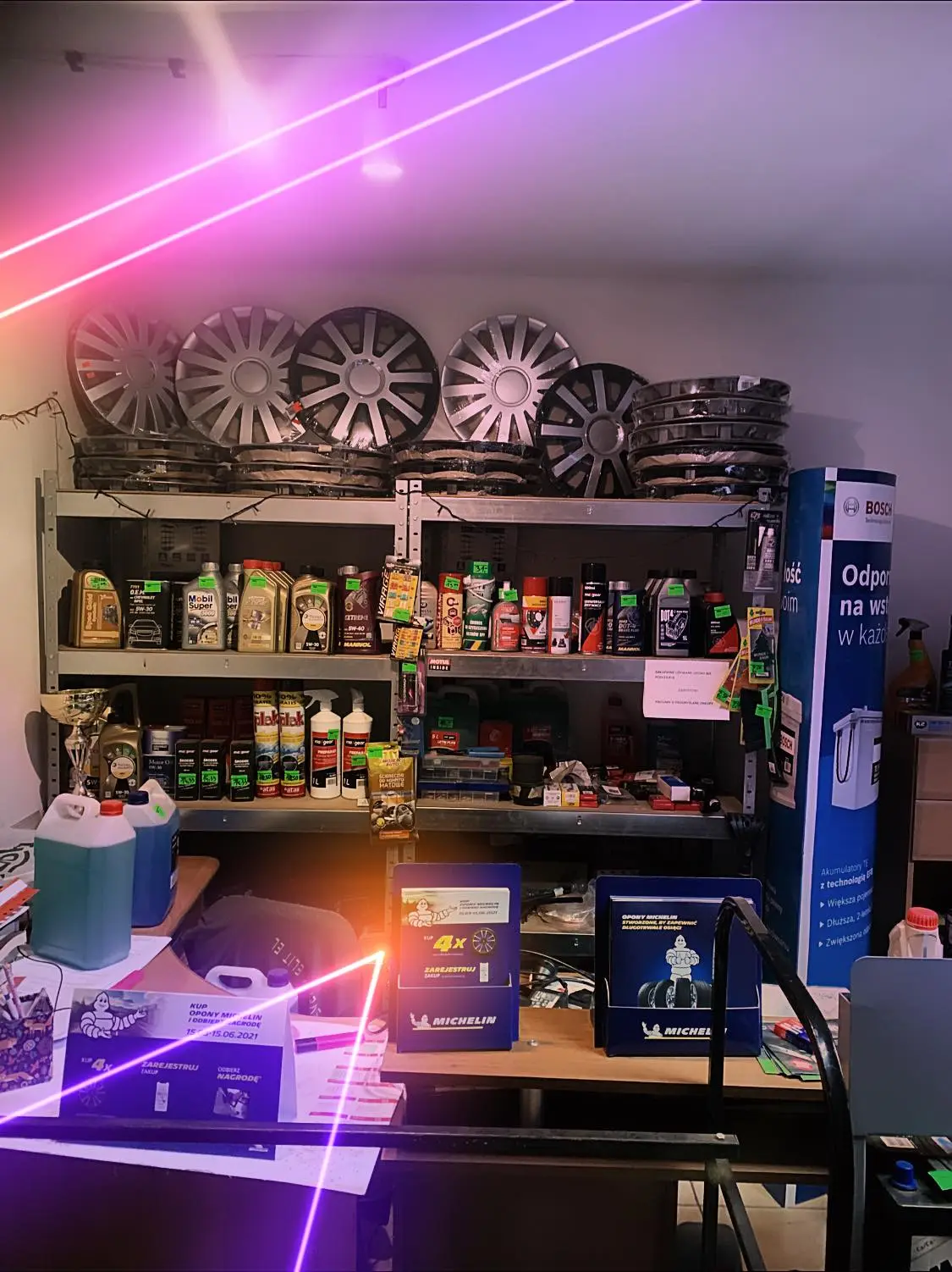 Zestaw artykułów motoryzacyjnych i płynów eksploatacyjnych ułożonych na półkach