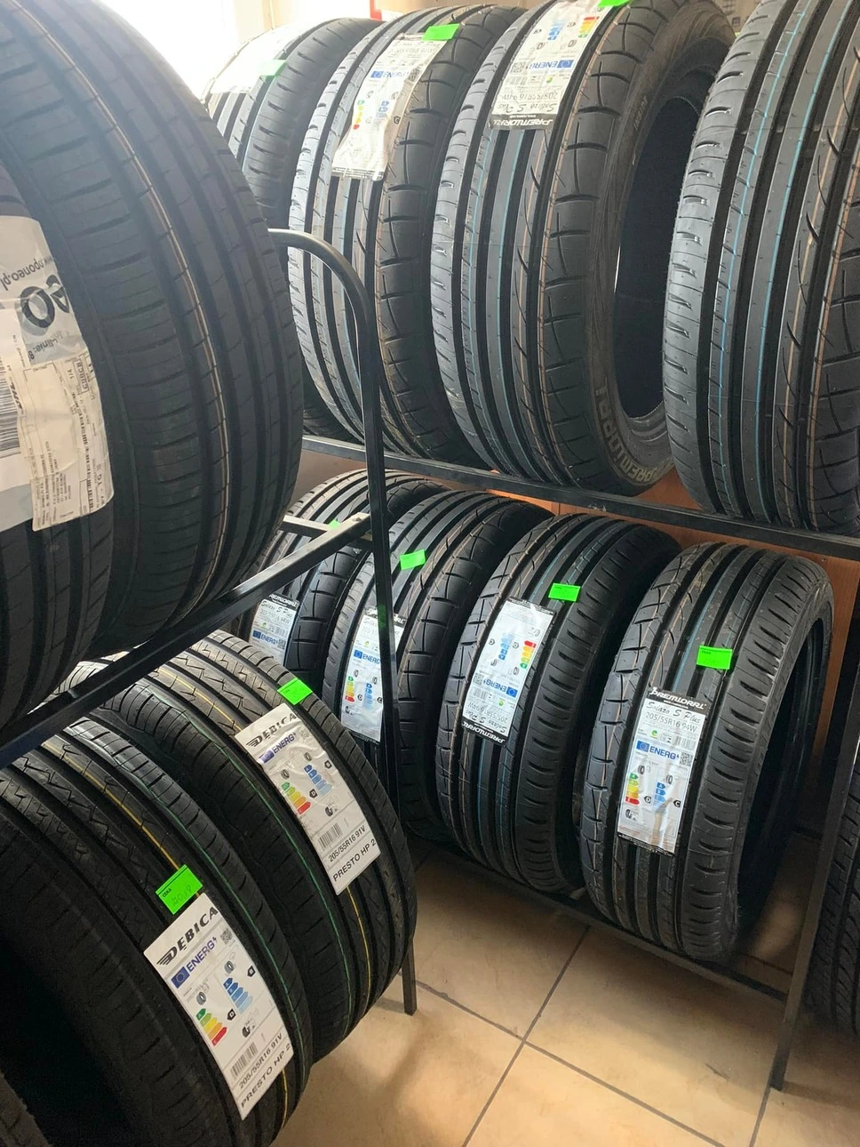Stelaże z ułożonymi obok siebie nowymi oponami