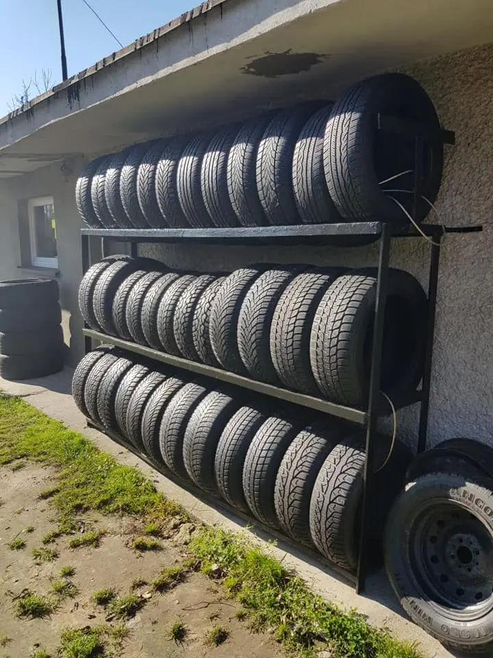 Regał z oponami stojący na zewnątrz biura